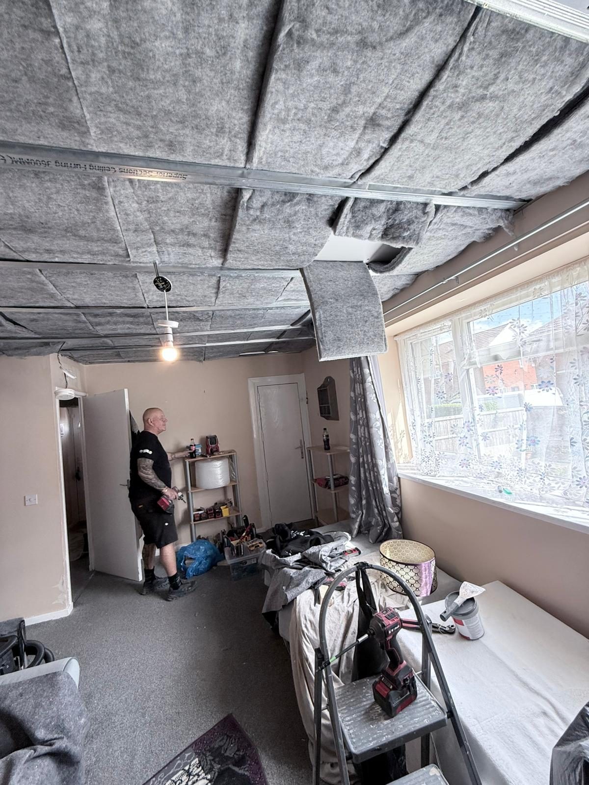 Soundproof suspended ceiling build-up with acoustic insulation in place across the room