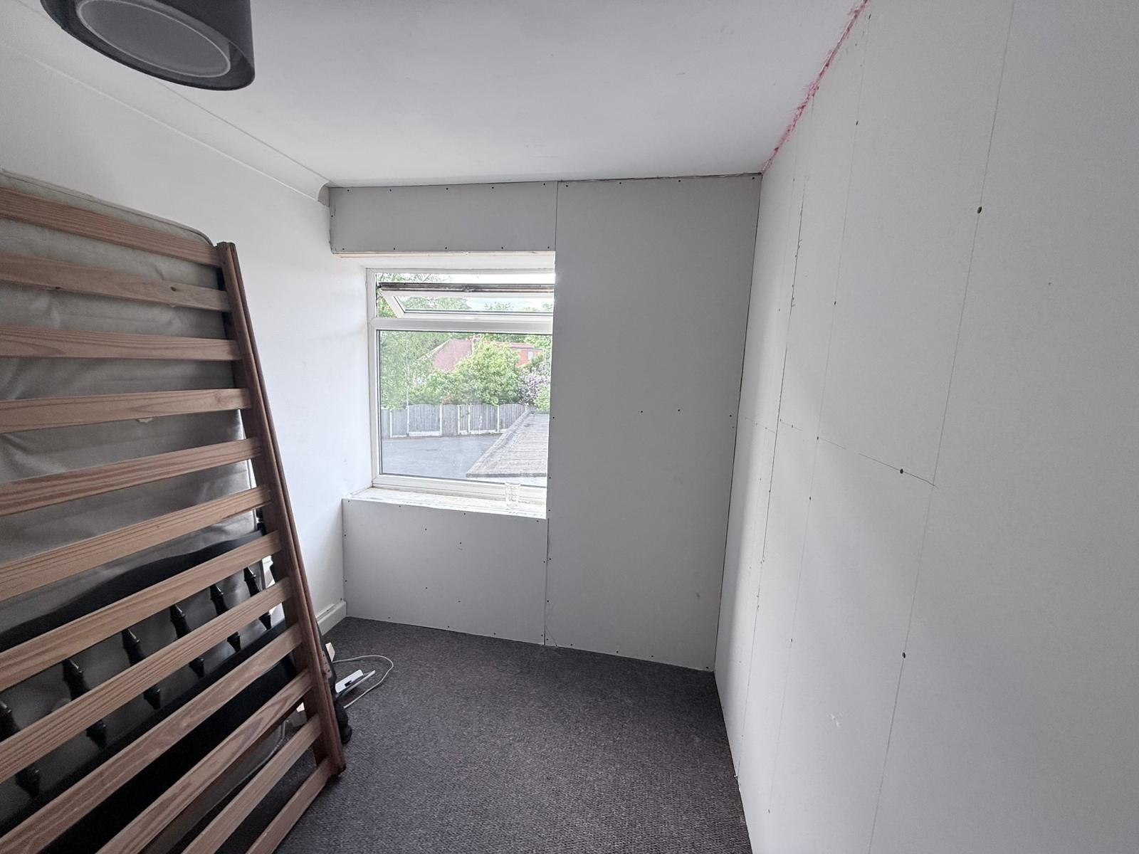 Bedroom external wall fully boarded over IWI — clean square finish to window reveal