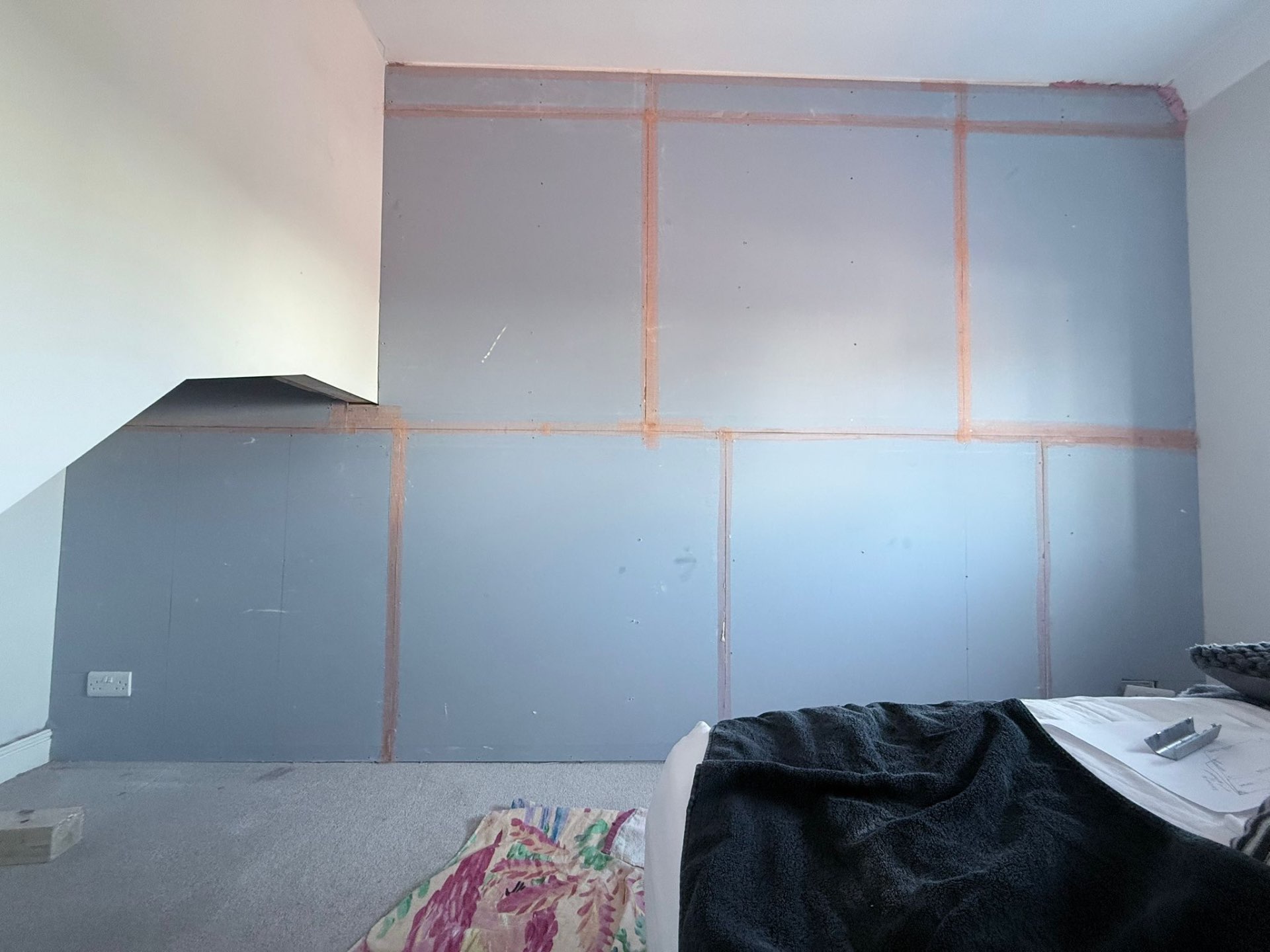 Soundproofing boards fitted around sloped ceiling and stair bulkhead detail