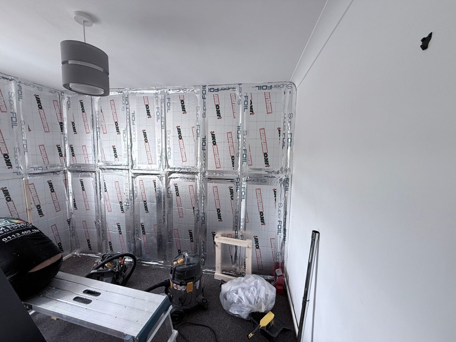 Full wall of foil-faced PIR insulation in place across IWI install, Roundhay LS17