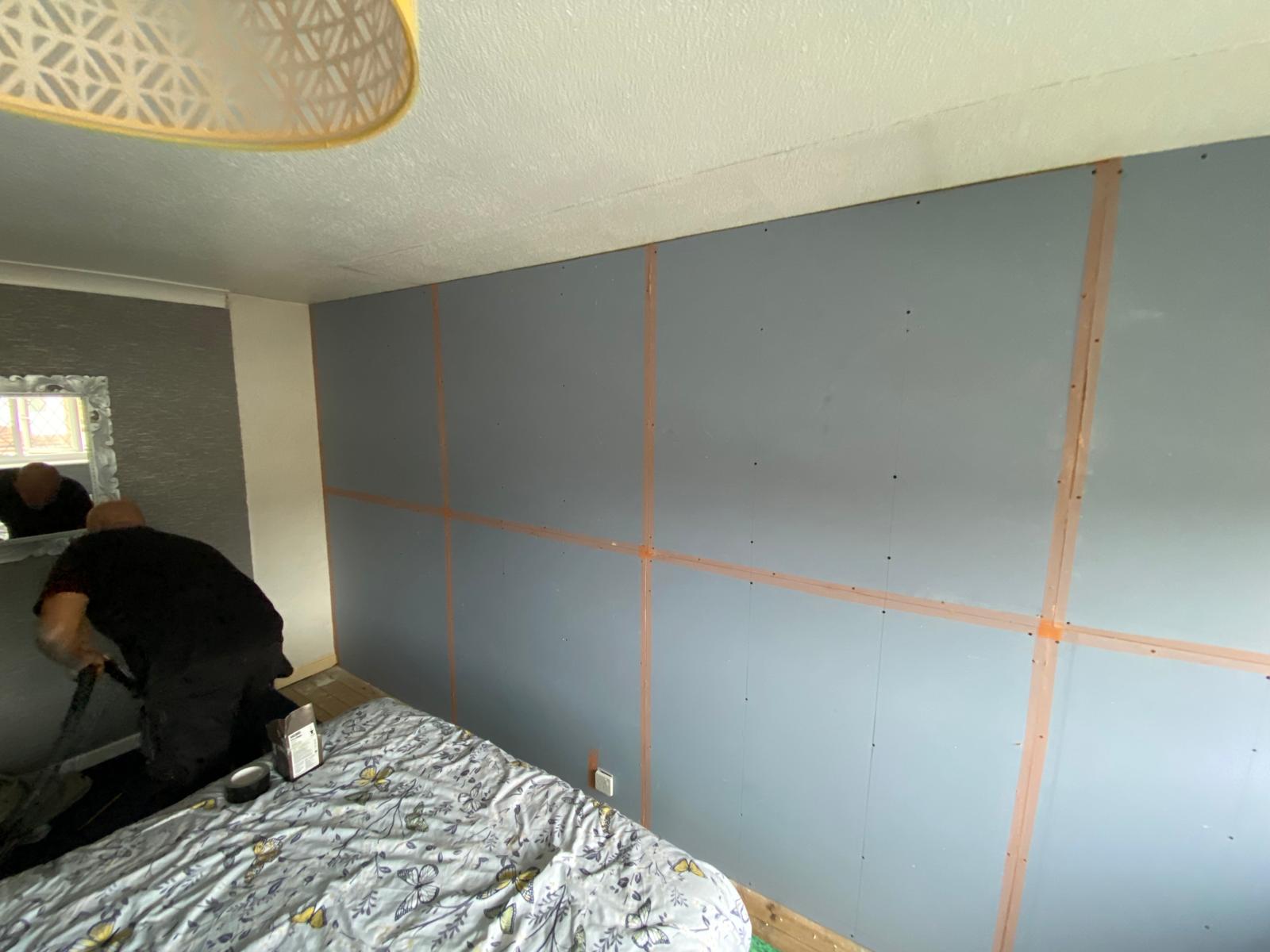 Acoustic plasterboard fully fitted across bedroom party wall with taped joints in Rothwell LS26